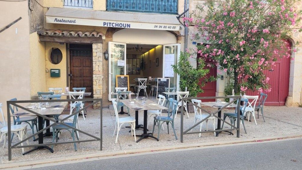 La façade ocre du restaurant, ses tables en terrasse, ses chaises métalliques et un laurier-rose
