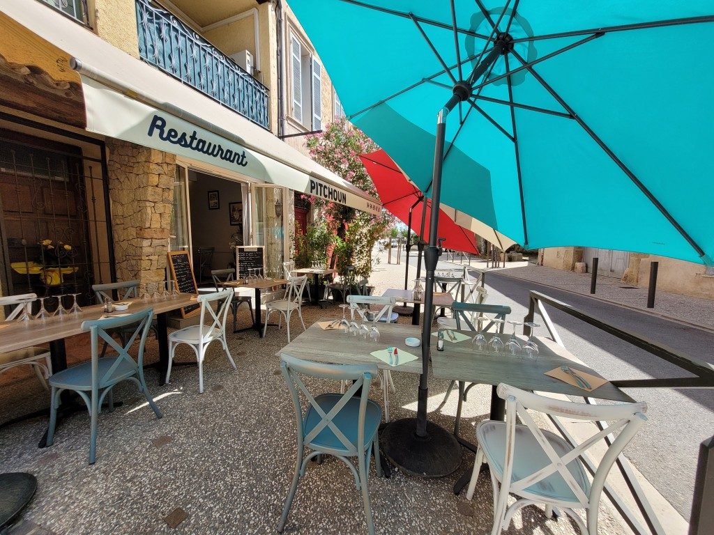 La terrasse ensoleillée, ses chaises bleues et son grand parasol turquoise